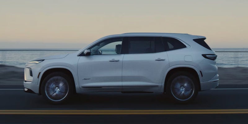 Buick Enclave Sport Touring safety section showing driver assistance features and SUV driving image.